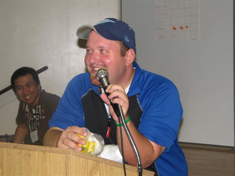 IMG_0476.JPG - Later, back at the Saturday night session, it’s Kiwanian & Past CKI-er Justin Garrow ready for more of his crazy and creative group games.  Just look at that mischevious face.  There’s a bit of the devil in those eyes.  You can not imagine where he gets these game ideas.  We’d never think of them.  They work!