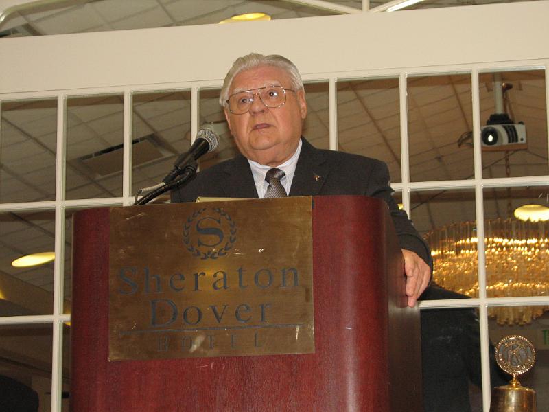 IMG_4482.JPG - The dean of KI’s District Secretary-Treasurers Ellis Stroup addresses members with his State of the District.  See the story on the Capital District Foundation for some of our service accomplishments.  Ellis is a 58 year Kiwanian as well as being our secretary-treasurer for 38 years.  How is that for experience!  He can still say 