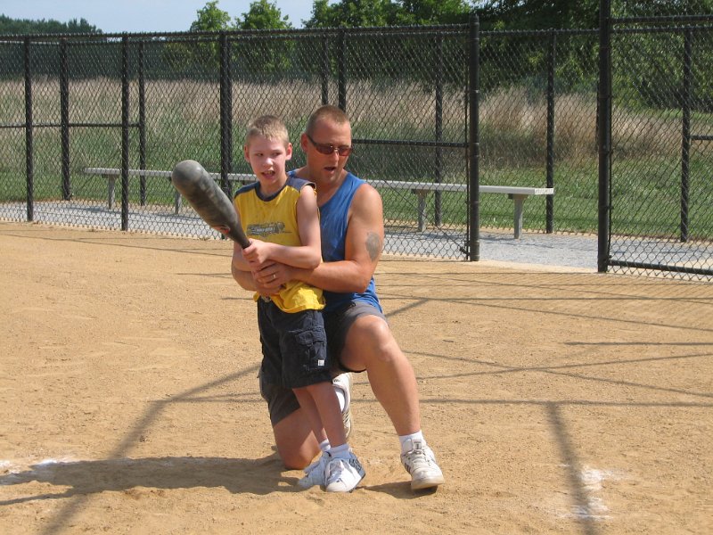 IMG_8877.JPG - A young father with great pride and concentration coaches and helps his son at the plate.  First it just the ability to have a chance to play.  Then its father and son together, sharing, learning and having fun.