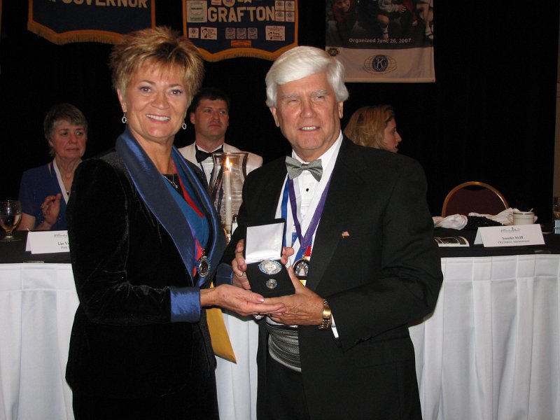 145.JPG - After dinner there were additional recognitions for contributions to the KIF “Eliminate Maternal/Neonatal Tetanus” program continued to come in during the convention. Since the announcement in Geneva, Switzerland, at the Kiwanis International Convention, through the close of our DCON, forty five Capital District Kiwanians and friends have earned Walter Zeller Charter Membership status. The results from just this brief period have raised over $56,250 just from the Capital District. These immunizations are otherwise unavailable if not supplied through Kiwanis and the United Nations (UNICEF). Past Governor Bob Cressy is presented his Walter Zeller Award by KI Trustee Jane Erickson.