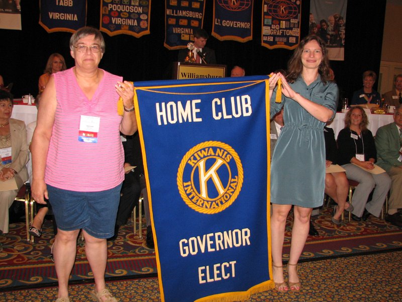 171.JPG - Marianne Gabor (right) of the Fairfax Club accepts the Gov. Elect. Home Club Banner from Stacy Bruss.